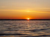 Leuchtender Morgenhimmel am Chiemsee mit aufgehender Sonne